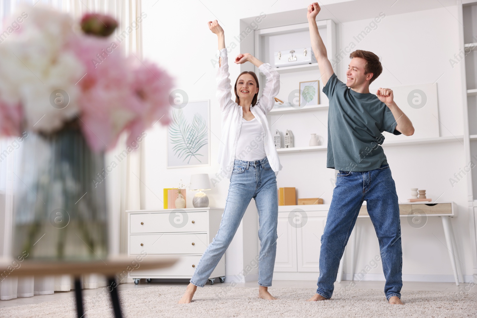 Happy young couple dancing together at home, low angle view Photo of Happy young couple dancing together at home, low angle view
