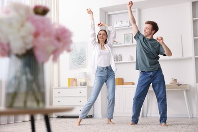 Photo of Happy young couple dancing together at home, low angle view