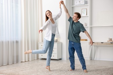 Photo of Happy young couple dancing together at home