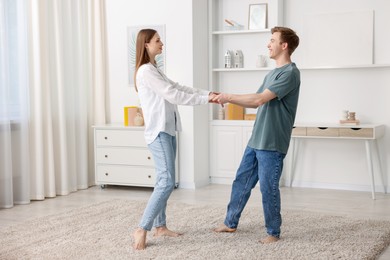 Photo of Happy young couple dancing together at home