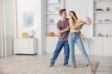 Photo of Happy young couple dancing together at home