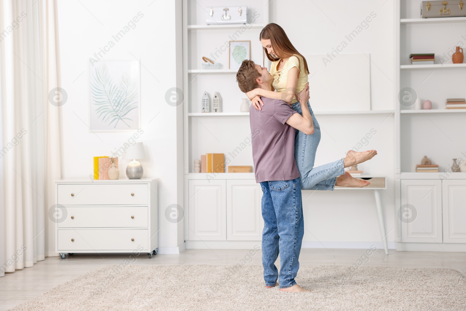 Photo of Happy young couple dancing together at home. Space for text