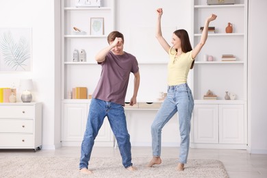 Photo of Happy young couple dancing together at home