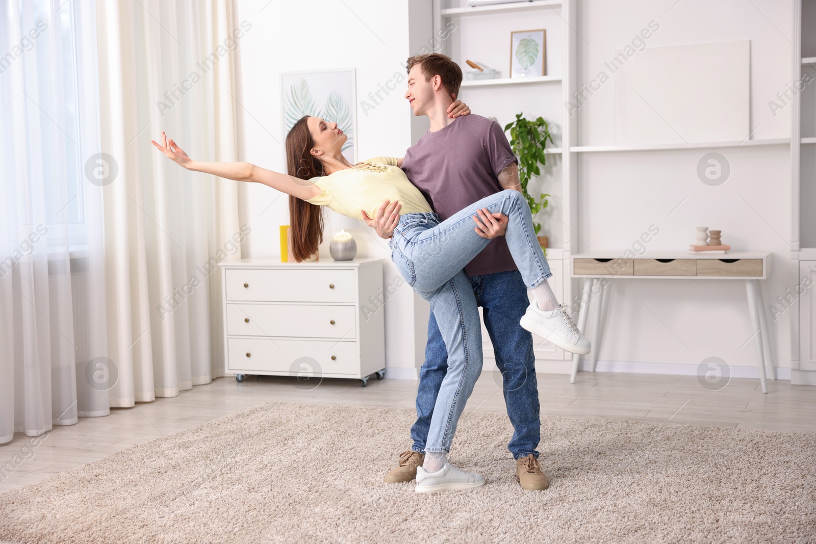 Carefree young couple dancing together at home Photo of Carefree young couple dancing together at home