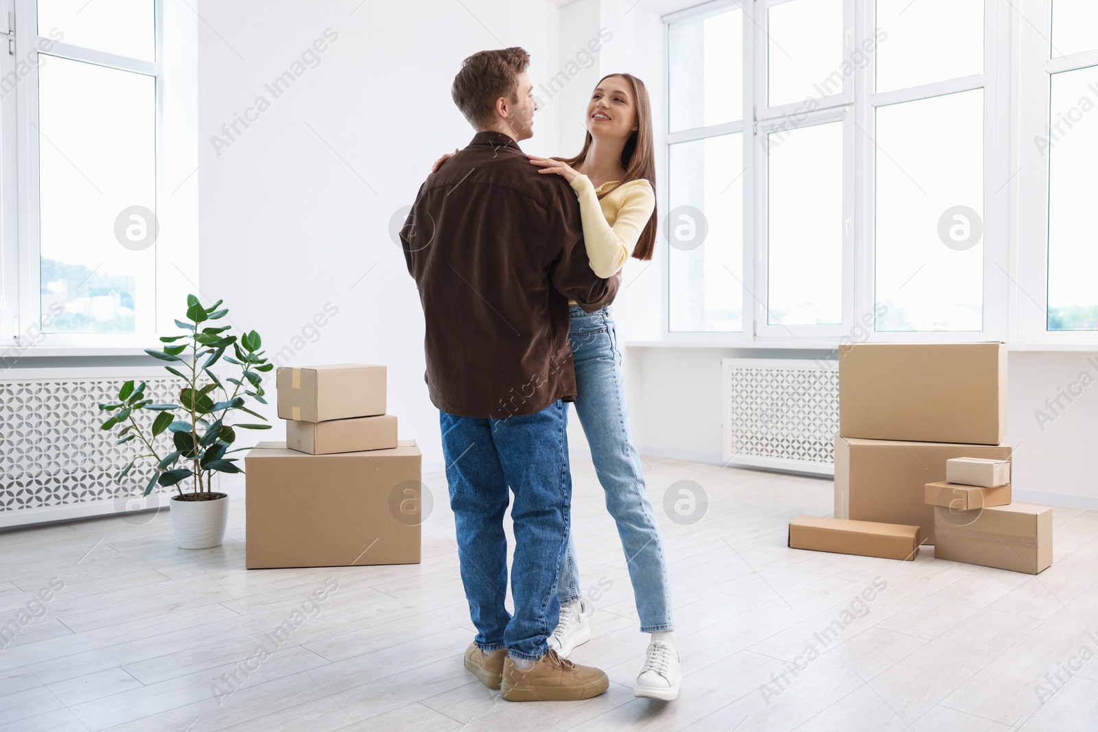 Happy young couple dancing and cardboard boxes at home. Moving day Photo of Happy young couple dancing and cardboard boxes at home. Moving day