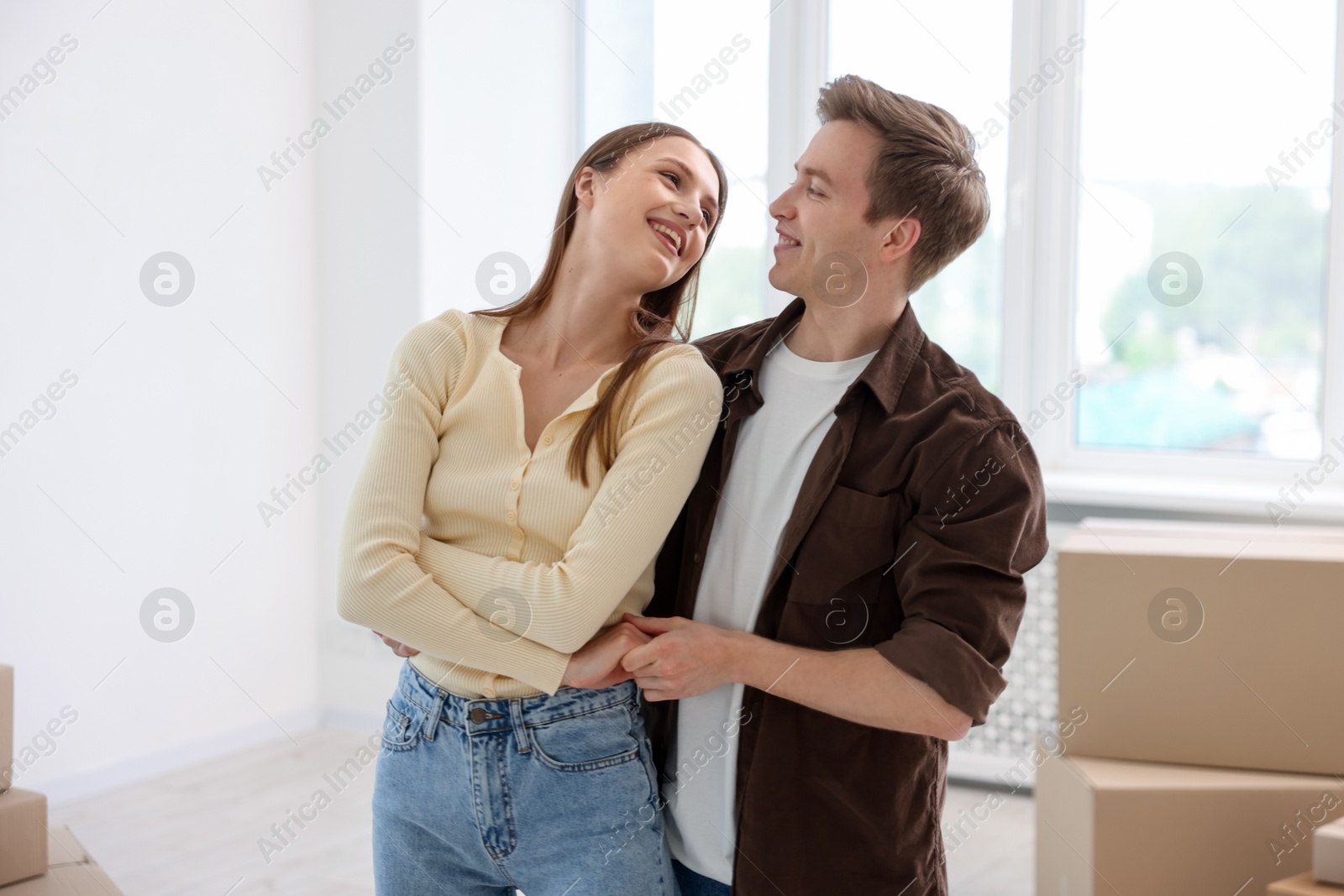 Happy young couple dancing and cardboard boxes at home. Moving day Photo of Happy young couple dancing and cardboard boxes at home. Moving day