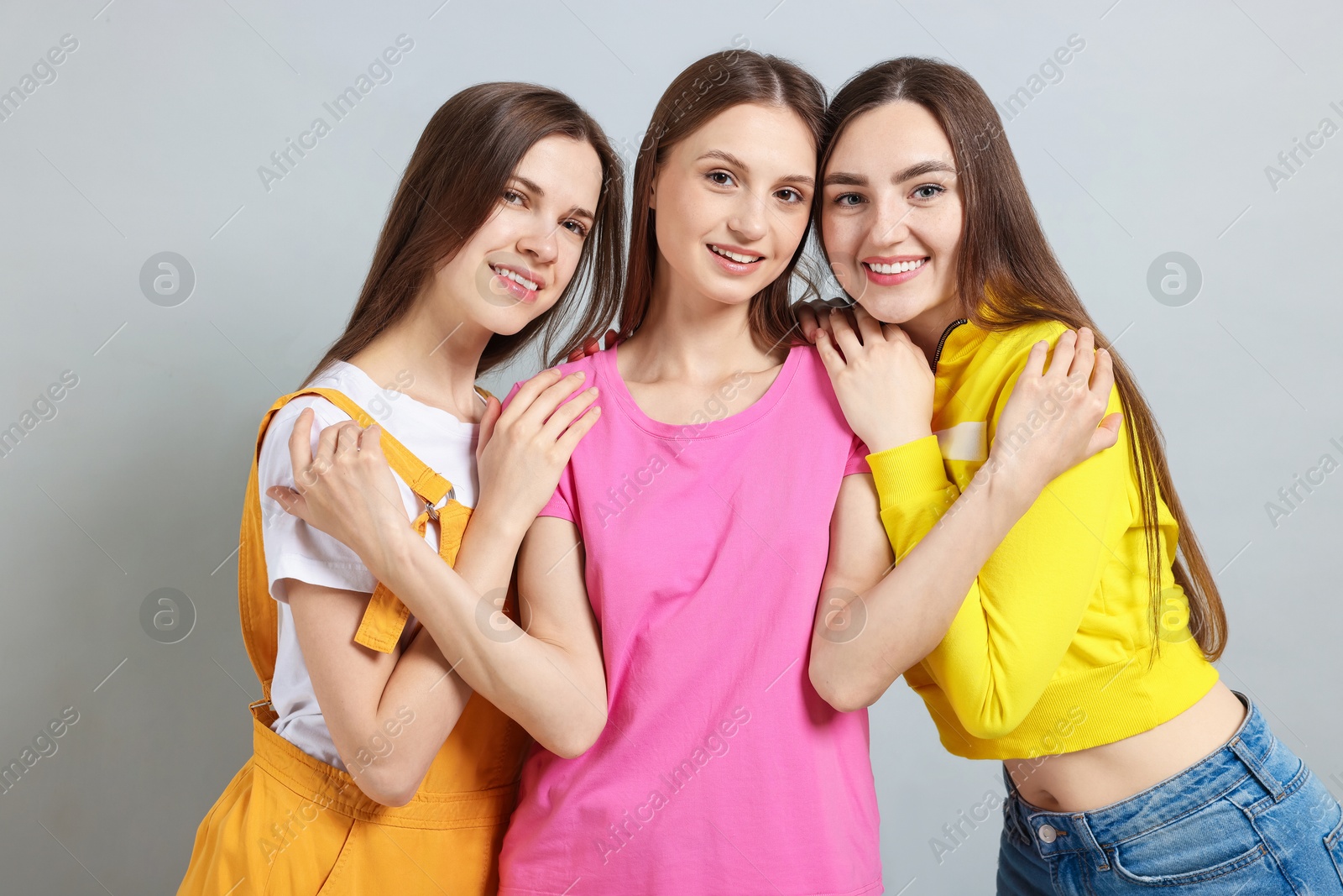 Photo of Friends hugging each other on light grey background