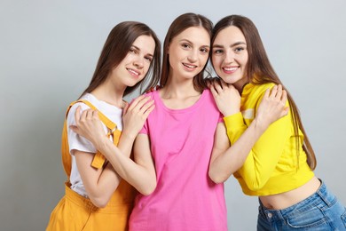 Photo of Friends hugging each other on light grey background
