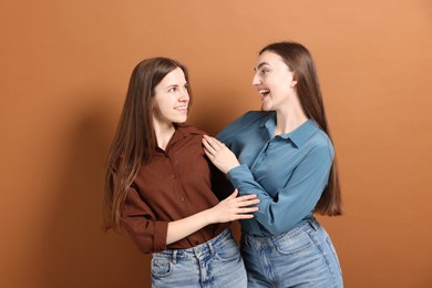 Photo of Friends hugging each other on pale brown background
