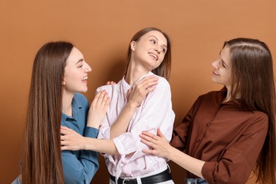 Photo of Friends hugging each other on pale brown background