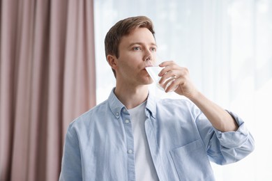 Photo of Man drinking water from glass at home