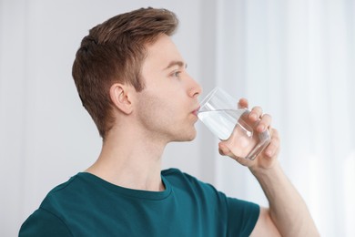 Photo of Man drinking water from glass at home