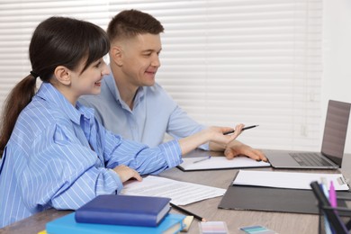 Photo of Consultant working with client at table in office. Business meeting