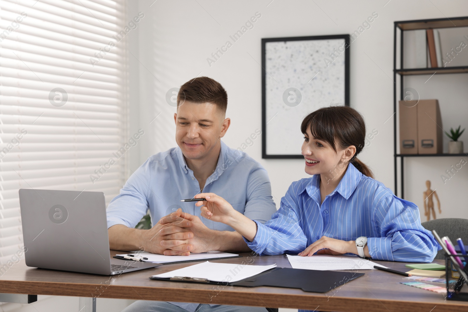 Consultant working with client at table in office. Business meeting Photo of Consultant working with client at table in office. Business meeting
