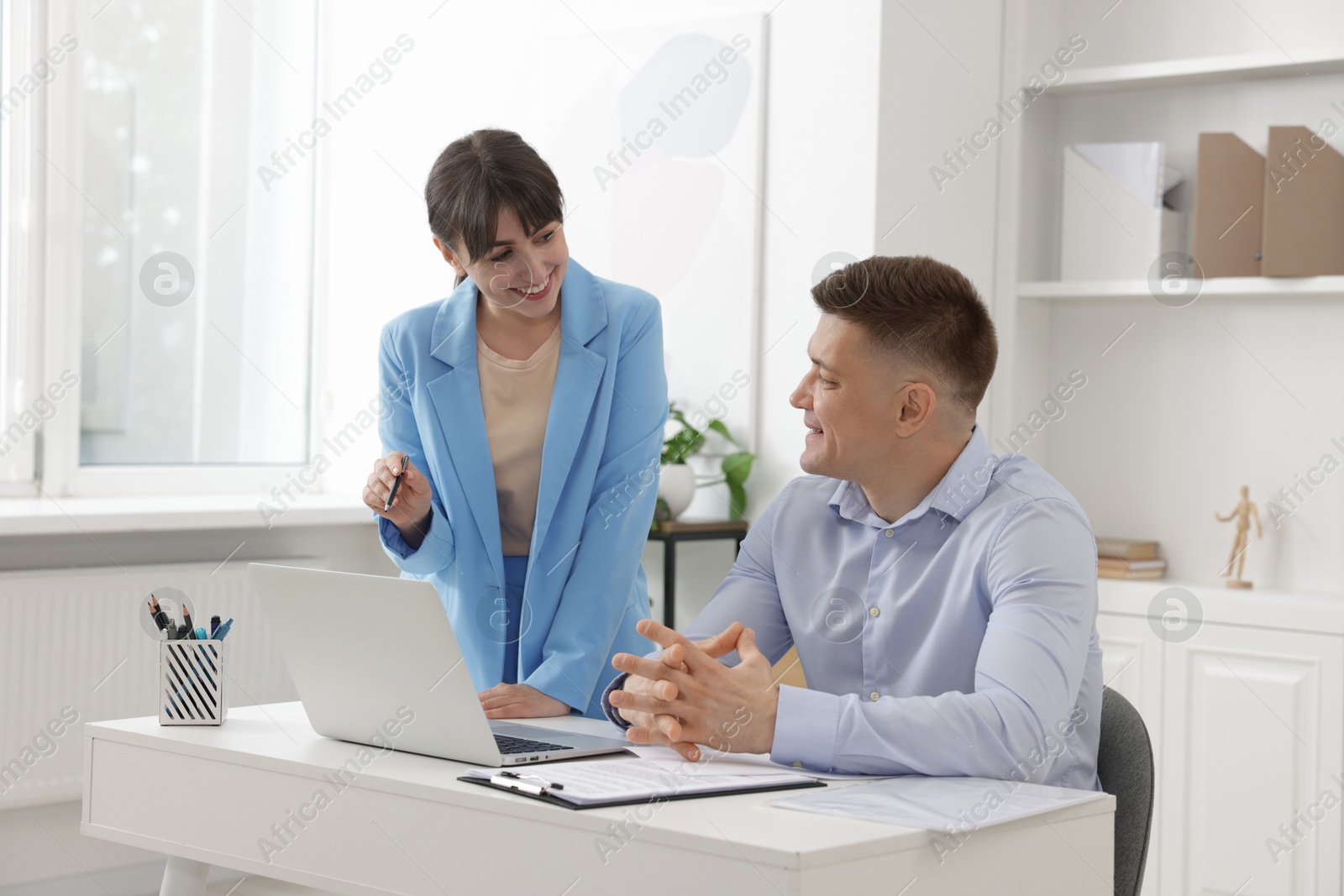 Consultant working with client at table in office. Business meeting Photo of Consultant working with client at table in office. Business meeting