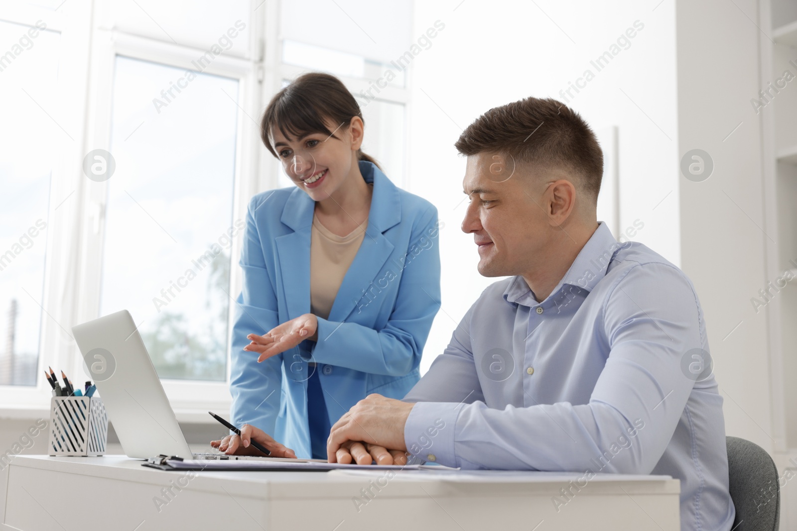 Consultant working with client at table in office. Business meeting Photo of Consultant working with client at table in office. Business meeting