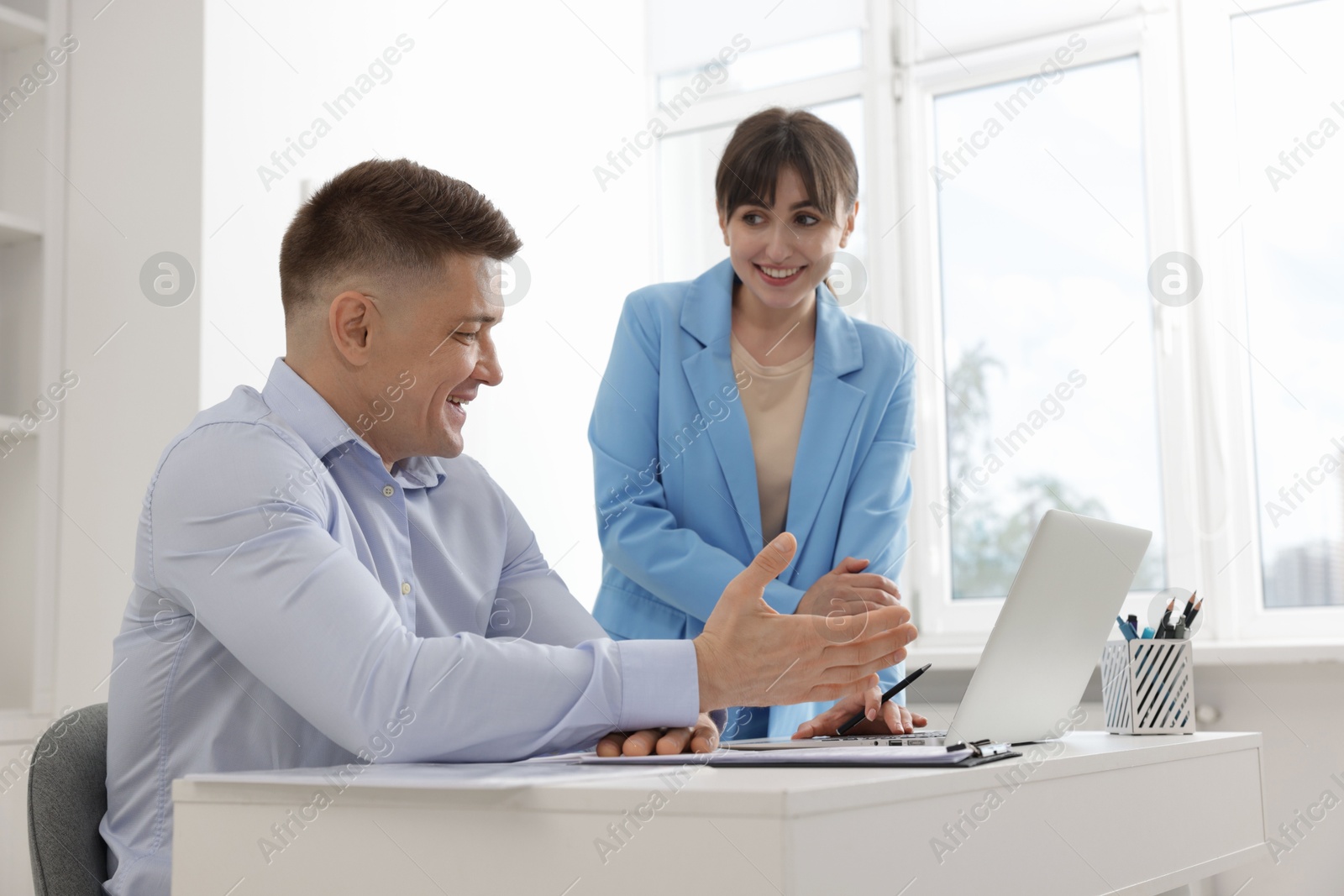 Consultant working with client at table in office. Business meeting Photo of Consultant working with client at table in office. Business meeting