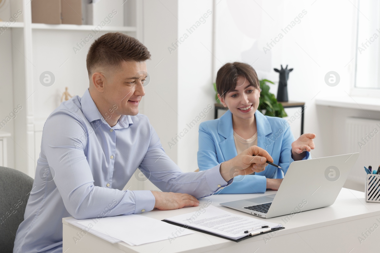 Consultant working with client at table in office. Business meeting Photo of Consultant working with client at table in office. Business meeting