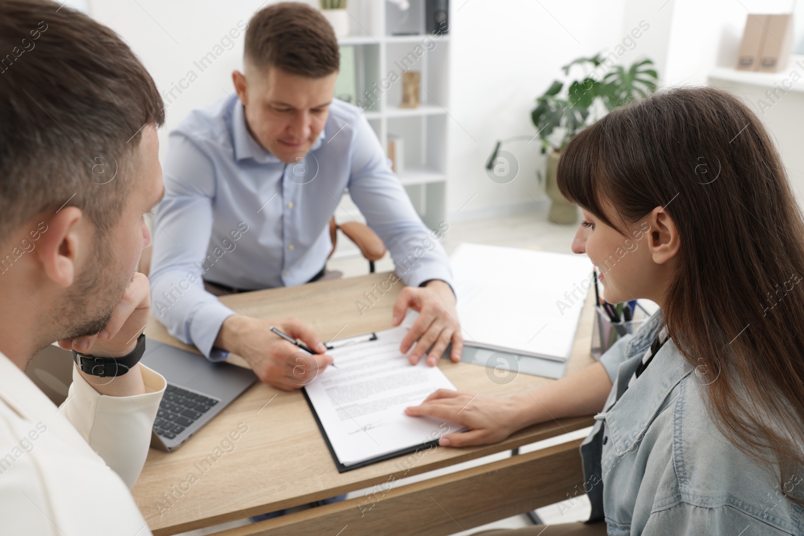 Photo of Couple having meeting with business consultant at table in office, selective focus