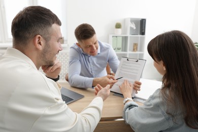 Photo of Couple having meeting with business consultant at table in office, selective focus