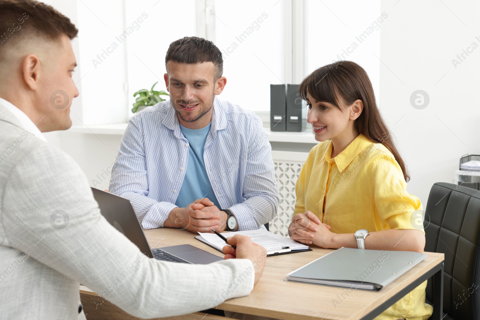 Photo of Couple having meeting with business consultant at table in office