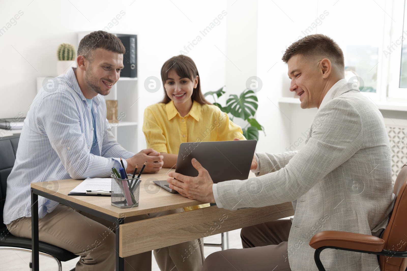Couple having meeting with business consultant at table in office Photo of Couple having meeting with business consultant at table in office