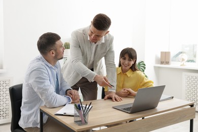 Photo of Couple having meeting with business consultant at table in office