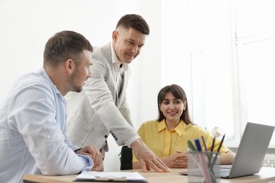 Photo of Couple having meeting with business consultant at table in office