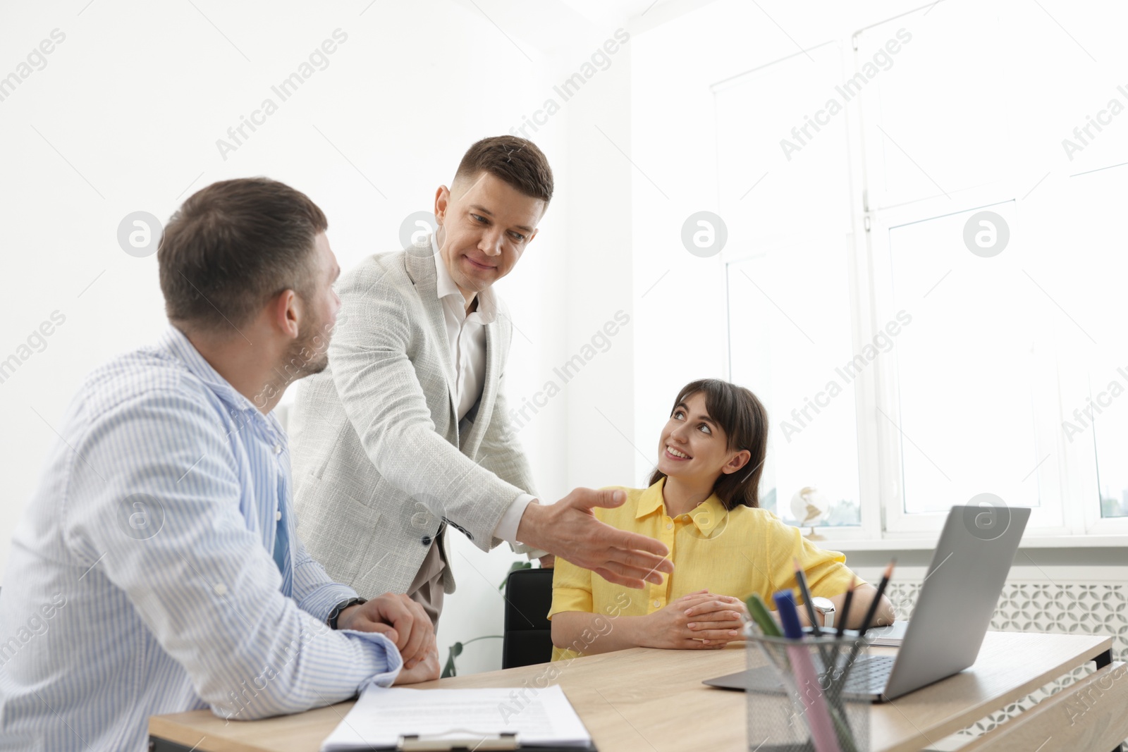 Couple having meeting with business consultant at table in office Photo of Couple having meeting with business consultant at table in office