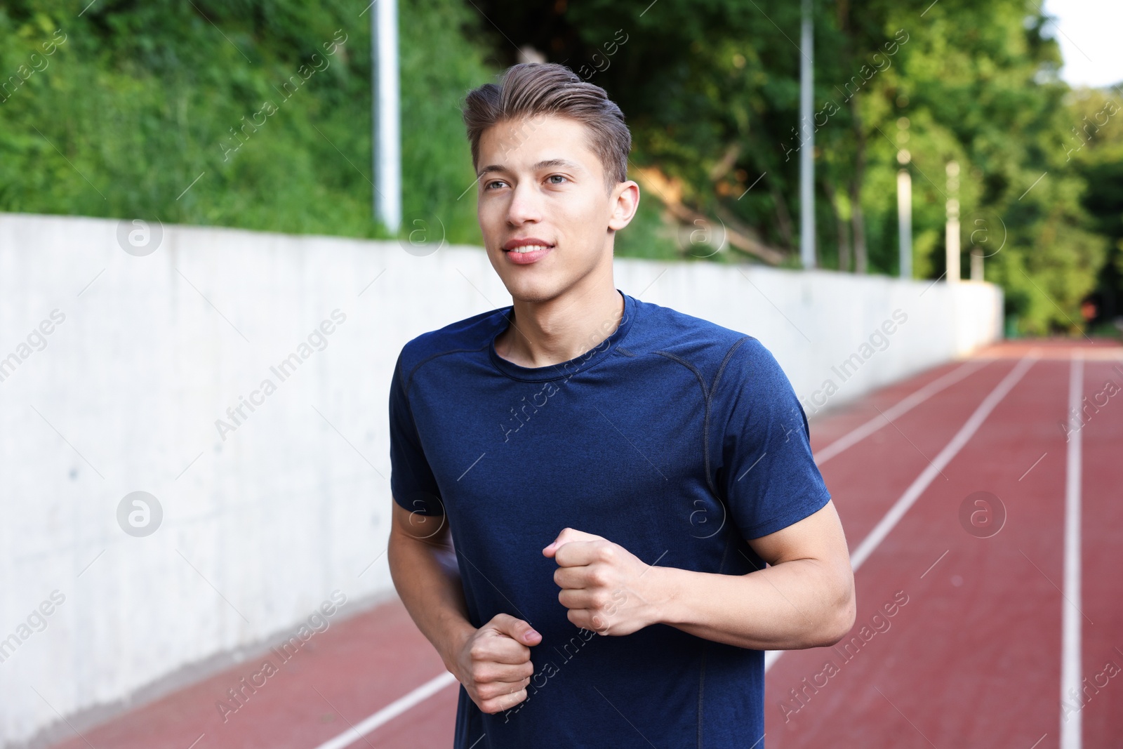 Photo of Sporty man running at stadium. Healthy lifestyle
