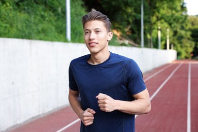 Photo of Sporty man running at stadium. Healthy lifestyle