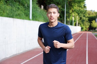Photo of Sporty man running at stadium. Healthy lifestyle