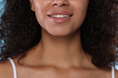 Photo of Smiling woman with glossy lip balm on her lips, closeup