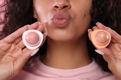 Photo of Woman with containers of lip balm, closeup