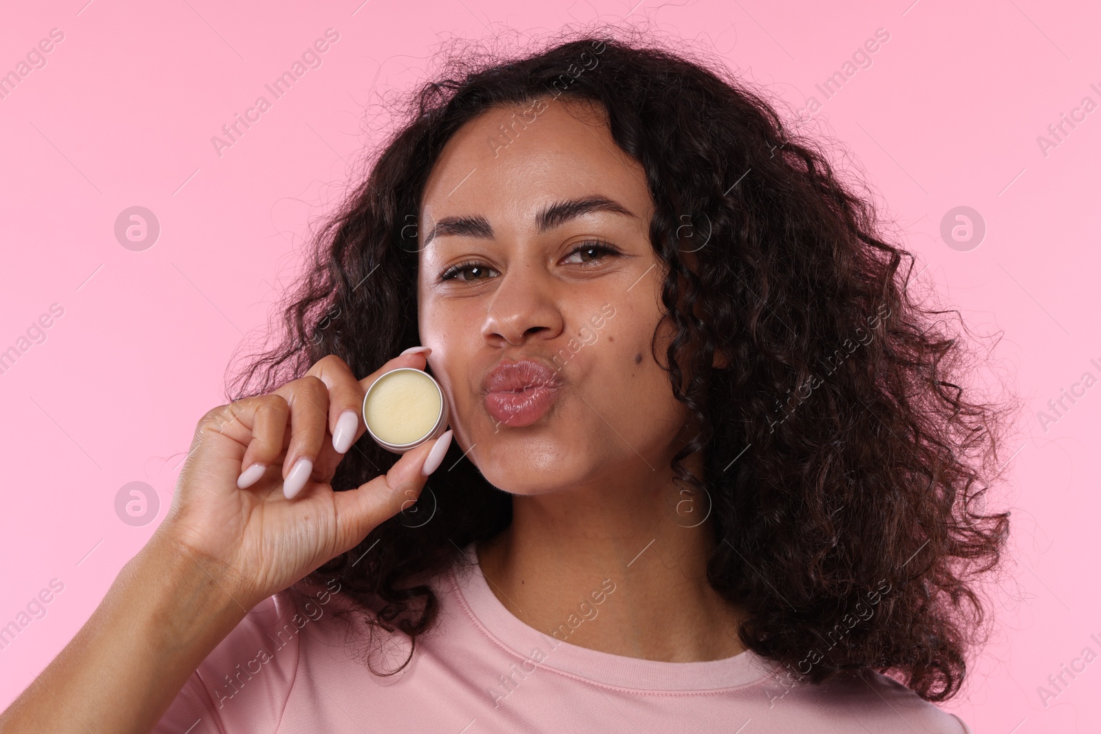Beautiful woman with lip balm on pink background Photo of Beautiful woman with lip balm on pink background