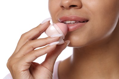 Photo of Smiling woman applying lip balm onto her lips on white background, closeup
