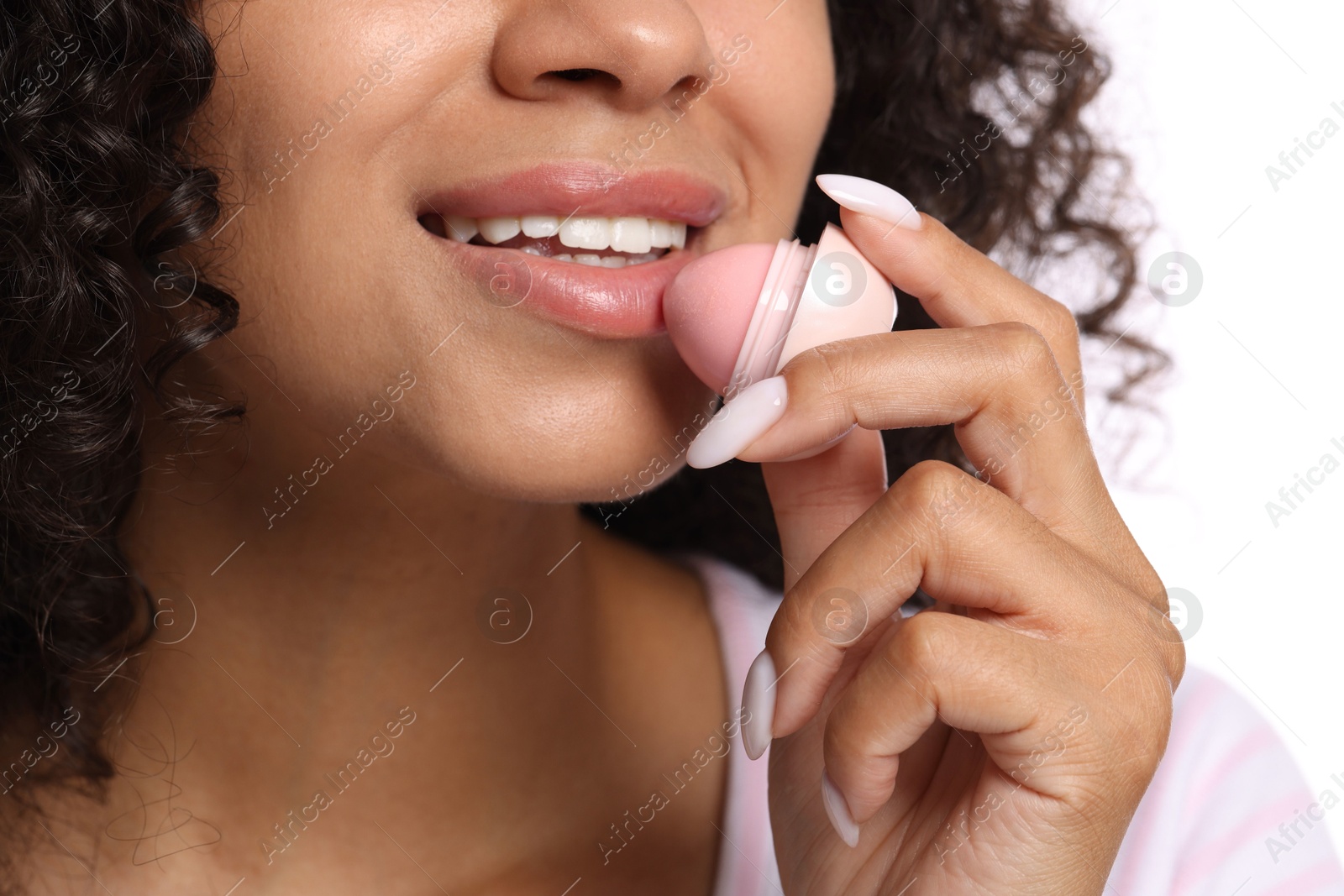Smiling woman applying lip balm onto her lips on white background, closeup Photo of Smiling woman applying lip balm onto her lips on white background, closeup