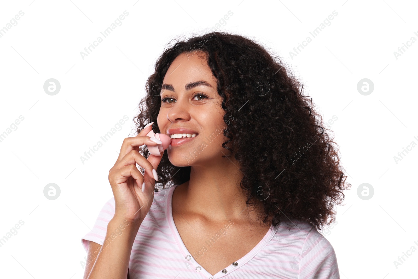 Smiling woman applying lip balm onto her lips on white background Photo of Smiling woman applying lip balm onto her lips on white background
