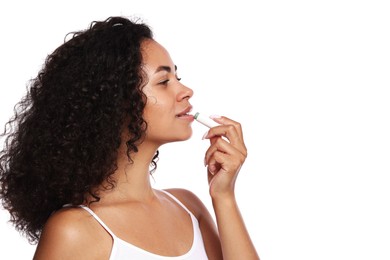 Photo of Beautiful woman applying lip balm onto her lips on white background