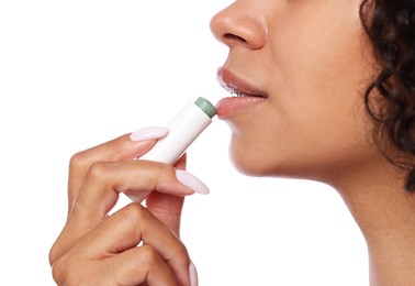 Photo of Woman applying lip balm onto her lips on white background, closeup
