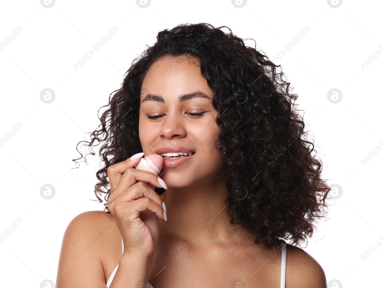 Smiling woman applying lip balm onto her lips on white background Photo of Smiling woman applying lip balm onto her lips on white background