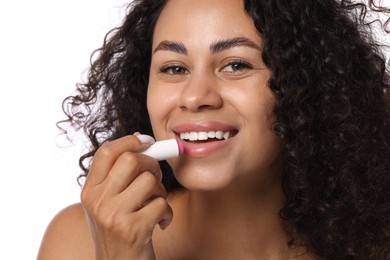 Photo of Smiling woman applying lip balm onto her lips on white background, closeup