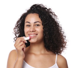 Photo of Smiling woman applying lip balm onto her lips on white background