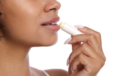 Photo of Woman applying lip balm onto her lips on white background, closeup
