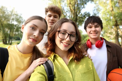 Photo of Group of teenagers taking selfie in park