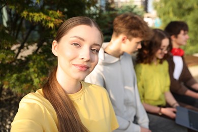 Photo of Teenagers spending time together in park, selective focus