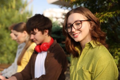 Photo of Teenagers spending time together in park, selective focus