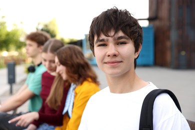 Photo of Teenagers spending time together outdoors, selective focus