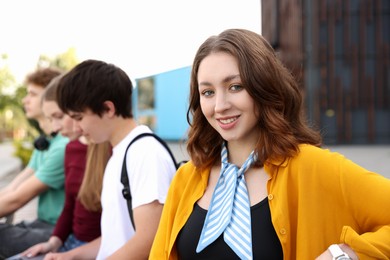 Photo of Teenagers spending time together outdoors, selective focus