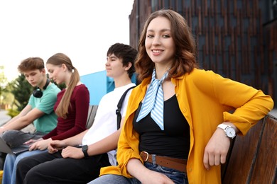 Photo of Teenagers spending time together outdoors, selective focus